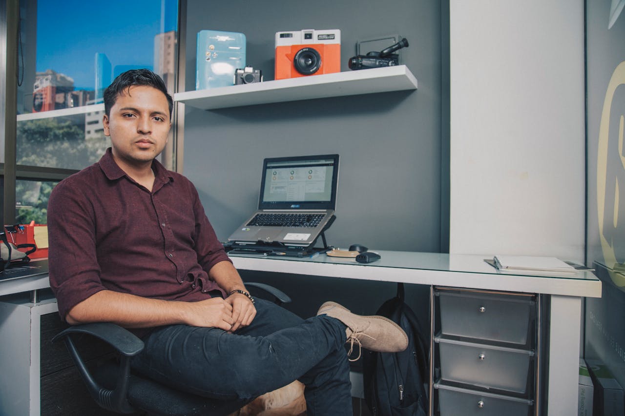 about-01 Young entrepreneur sitting at office desk with laptop and gadgets, Antioquia, Colombia.